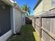Narrow side yard with wood fence, grass, and access gate to the backyard at 633 Cypress Tree Ct, Orlando, FL 32825