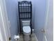 Small toilet room featuring a toilet, toilet paper holder and shelving unit at 633 Cypress Tree Ct, Orlando, FL 32825