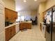 Well-lit kitchen featuring tile floors, wooden cabinets, and stainless steel refrigerator at 742 Chamberlin Trl, St Cloud, FL 34772