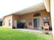 A covered patio with ample space for outdoor dining and relaxation overlooks the green lawn at 742 Chamberlin Trl, St Cloud, FL 34772