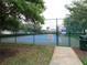The community tennis court has a vibrant blue surface and is surrounded by a secure fence at 742 Chamberlin Trl, St Cloud, FL 34772