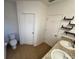 Bright bathroom featuring a double sink vanity, toilet and shelving at 939 Anna Pl, Davenport, FL 33837
