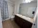 Bathroom featuring a double sink vanity, toilet, and shower/tub combo with a floral curtain at 939 Anna Pl, Davenport, FL 33837