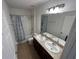 Bathroom featuring a double sink vanity, toilet, and shower/tub combo with a floral curtain at 939 Anna Pl, Davenport, FL 33837