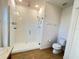 Bathroom with sleek glass-enclosed shower, toilet, and neutral tile flooring at 939 Anna Pl, Davenport, FL 33837