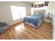 Well-lit bedroom features wood flooring, a comfortable bed, and decorative artwork to complete a cozy scene at 939 Anna Pl, Davenport, FL 33837