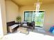 View of the home's covered patio, including furnishings and slider to the yard at 939 Anna Pl, Davenport, FL 33837