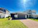 Beautiful single Gathering home with a well-maintained lawn, brick paver driveway and attached two car garage at 939 Anna Pl, Davenport, FL 33837
