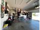 Organized garage interior offers concrete floors and storage, with an open door providing a view of the driveway at 939 Anna Pl, Davenport, FL 33837