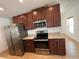 Modern kitchen featuring stainless steel appliances, dark wood cabinets, and granite countertops at 939 Anna Pl, Davenport, FL 33837