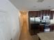 Long view of kitchen adjacent to hall with stainless steel refrigerator, dark wood cabinets and granite countertops at 939 Anna Pl, Davenport, FL 33837