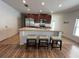 Well-lit open concept kitchen with stainless steel appliances and granite counters, plus seating at the island at 939 Anna Pl, Davenport, FL 33837