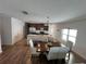 Open living space with wood floors features kitchen with island and eat in dining area with bright windows at 939 Anna Pl, Davenport, FL 33837
