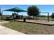 A play area with green sun shade, swings, slides, benches, and lush grass at 939 Anna Pl, Davenport, FL 33837