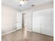 Bedroom featuring wood-look floors, a closet, and a doorway to another room at 9513 Bahia Rd, Ocala, FL 34472
