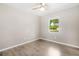 Bright bedroom featuring wood-look floors, a ceiling fan, and a window offering natural light at 9513 Bahia Rd, Ocala, FL 34472