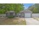 Lovely gray home featuring a single-car garage, and mature landscaping at 9513 Bahia Rd, Ocala, FL 34472