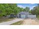 Charming gray home featuring a single-car garage and mature landscaping at 9513 Bahia Rd, Ocala, FL 34472