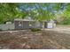 Gray home featuring a single-car garage, white trim and mature landscaping at 9513 Bahia Rd, Ocala, FL 34472