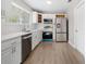 Bright and modern kitchen with white cabinets, stainless steel appliances, and wood-look floors at 9513 Bahia Rd, Ocala, FL 34472