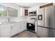 This modern kitchen features white cabinets, stainless steel appliances, and lots of light at 9513 Bahia Rd, Ocala, FL 34472