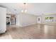 Open-concept room featuring the entry door, ceiling fan, kitchen, and wood-look floors at 9513 Bahia Rd, Ocala, FL 34472