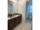 Bathroom with double sink vanity, granite counters and tiled shower at 11713 Tidal Alley Trl, Orlando, FL 32832