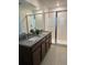Bathroom with dual granite sinks, vanity, tiled floor and glass enclosed shower at 11713 Tidal Alley Trl, Orlando, FL 32832