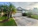 Attractive house with a brick paver driveway, two-car garage, and tropical landscaping at 14313 Dulcimer Ct, Orlando, FL 32837