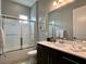 Well-lit bathroom featuring a shower with glass doors, a large mirror, and modern vanity at 236 Villa Domani Cir, Davenport, FL 33896