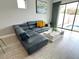 Comfortable living room with a sectional sofa, stylish coffee table, and access to the patio/pool area at 236 Villa Domani Cir, Davenport, FL 33896