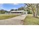 Charming single-story home with a metal roof, fenced yard, a long driveway, and a beautiful lawn at 616 Se 31St Ter, Ocala, FL 34471