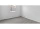 A bright, empty bedroom featuring plush gray carpeting and a window at 6389 Clover St, Lake Hamilton, FL 33851
