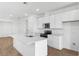 Modern kitchen boasts white cabinets, stainless steel appliances, and a center island with a sink at 6389 Clover St, Lake Hamilton, FL 33851