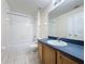 Bright bathroom features wood vanity, bath tub and white tile flooring at 205 Minniehaha Cir, Haines City, FL 33844