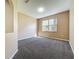 Empty carpeted room with tan walls and a large window at 205 Minniehaha Cir, Haines City, FL 33844