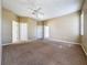 Spacious carpeted bedroom with a ceiling fan and multiple doors at 205 Minniehaha Cir, Haines City, FL 33844