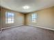 Simple bedroom with neutral walls, carpet, and two windows for natural light at 205 Minniehaha Cir, Haines City, FL 33844