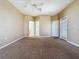 Large carpeted bedroom with a ceiling fan and multiple doors at 205 Minniehaha Cir, Haines City, FL 33844