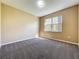 Empty carpeted room with tan walls and a large window at 205 Minniehaha Cir, Haines City, FL 33844