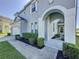 Arched entrance of this two-story home boasts mature landscaping and an inviting walkway to the front door at 205 Minniehaha Cir, Haines City, FL 33844