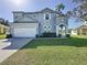 Charming two-story home with manicured lawn and attached two car garage, and ornate architectural details at 205 Minniehaha Cir, Haines City, FL 33844