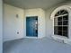 The blue front door is framed by an arched window and textured walls, creating a welcoming entrance at 205 Minniehaha Cir, Haines City, FL 33844