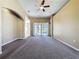 Comfortable living room with plush carpet, ceiling fan, and view of backyard through sliding glass doors at 205 Minniehaha Cir, Haines City, FL 33844