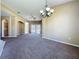 Expansive living room with carpet, ceiling fan, chandelier, and seamless connection to kitchen and outdoor spaces at 205 Minniehaha Cir, Haines City, FL 33844