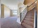 Open-concept living space with carpeted floors, leading to the staircase with detailed ironwork and a column at 205 Minniehaha Cir, Haines City, FL 33844