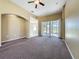 Spacious living room with brown carpet, ceiling fan, and sliding glass doors to the backyard at 205 Minniehaha Cir, Haines City, FL 33844