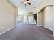 Carpeted living room with large front windows and view of staircase and entry way at 205 Minniehaha Cir, Haines City, FL 33844