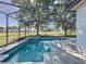 Relaxing screened pool with an attached spa and view of the backyard at 205 Minniehaha Cir, Haines City, FL 33844