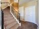 Carpeted staircase with black metal railing leads to the upper level, with neutral walls and white doors at 205 Minniehaha Cir, Haines City, FL 33844